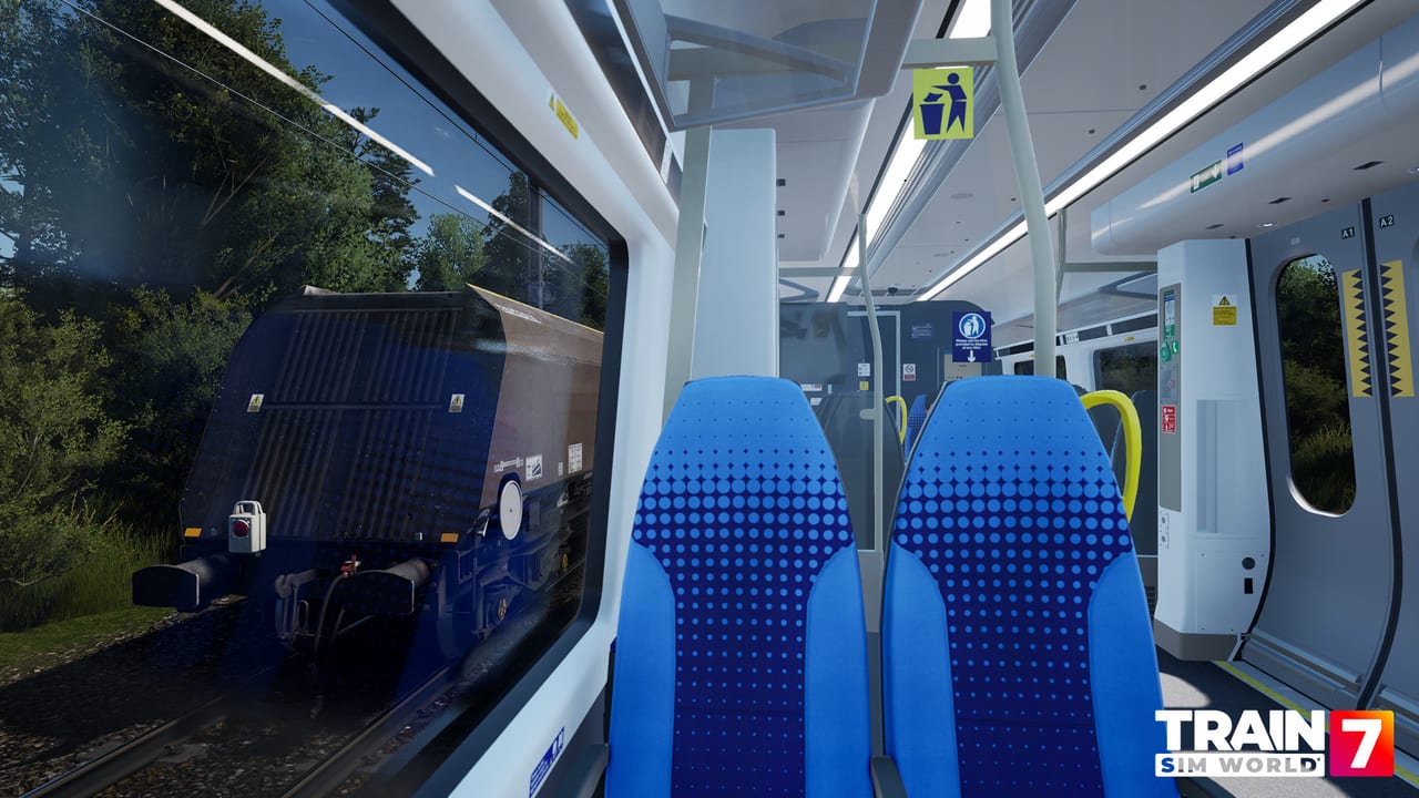 Fahrgastraum einer Northern-Einheit, während ein Schüttgutwagen am Fenster vorbeizieht, in Train Sim World 7